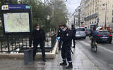 Police officers stand by a knife, seen on the ground, in Paris, September 25, 2020. (Soufian Fezzani Via AP)