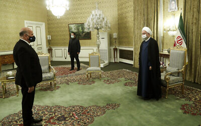 In this photo released by the official website of the office of the Iranian Presidency, President Hassan Rouhani, right, welcomes Iraqi Foreign Minister Fuad Hussein for their meeting, in Tehran, Iran, September 26, 2020. (Iranian Presidency Office via AP)