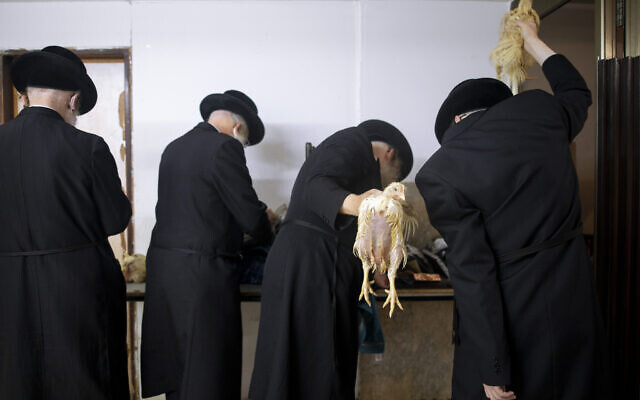 Ultra-Orthodox Jews swing chickens over their heads during the Kaparot ritual, in Bnei Brak, Israel, September 27, 2020. (AP Photo/Oded Balilty) Ultra-Orthodox Jews swing chickens over their heads during the Kaparot ritual, in Bnei Brak, Israel, September 27, 2020. (AP Photo/Oded Balilty)