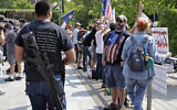 A man standing with members of Patriot Prayer and other groups supporting gun rights wears a gun during a rally, Aug. 18, 2018, at City Hall in Seattle. (AP Photo/Ted S. Warren)
