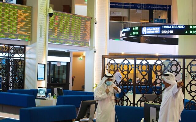 Two Emiratis wearing face masks due to the coronavirus pandemic talk on the floor of the Dubai Financial Market in Dubai, United Arab Emirates, July 7, 2020 (AP Photo/Jon Gambrell) Two Emiratis wearing face masks due to the coronavirus pandemic talk on the floor of the Dubai Financial Market in Dubai, United Arab Emirates, July 7, 2020 (AP Photo/Jon Gambrell)