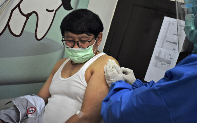 A medical worker gives coronavirus vaccine candidate to a volunteer during a trial at a community health center in Bandung, West Java, Indonesia, Friday, Aug. 14, 2020. Indonesia's only vaccine production company has started this week a so-called phase 3 clinical trials to test a potential coronavirus vaccine developed by a Chinese company. (AP Photo/Kusumadirezza) A medical worker gives coronavirus vaccine candidate to a volunteer during a trial at a community health center in Bandung, West Java, Indonesia, Friday, Aug. 14, 2020. Indonesia's only vaccine production company has started this week a so-called phase 3 clinical trials to test a potential coronavirus vaccine developed by a Chinese company. (AP Photo/Kusumadirezza)