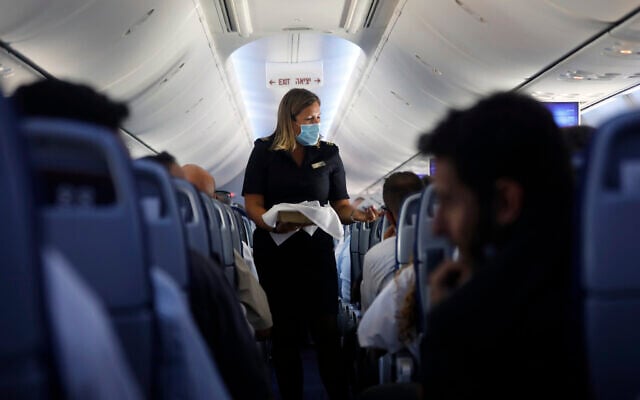 A flight attendant hands out chocolates with a greeting card to passengers on an El Al plane from Israel en route to Abu Dhabi, United Arab Emirates, Monday, Aug. 31, 2020. (Nir Elias/Pool Photo via AP) A flight attendant hands out chocolates with a greeting card to passengers on an El Al plane from Israel en route to Abu Dhabi, United Arab Emirates, Monday, Aug. 31, 2020. (Nir Elias/Pool Photo via AP)
