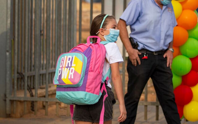 An elementary school student wearing a mask amid the coronavirus pandemic makes her way to class on the first day of school in Kfar Yona, Sept. 1, 2020. (AP Photo/Ariel Schalit) An elementary school student wearing a mask amid the coronavirus pandemic makes her way to class on the first day of school in Kfar Yona, Sept. 1, 2020. (AP Photo/Ariel Schalit)