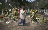 A grave digger walks in the COVID-19 section of the cemetery of San Lorenzo Tezonco Iztapalapa on the outskirts of Mexico City, Sept. 1, 2020. (AP Photo/Marco Ugarte)