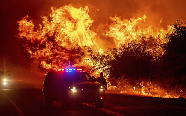 Flames lick above vehicles on Highway 162 as the Bear Fire burns in Oroville, California, on Sept. 9, 2020 (AP Photo/Noah Berger)