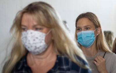 Israeli top model Bar Refaeli, right, and her mother, Tzipi Rafaieli wear face masks amid the coronavirus pandemic as they leave a courtroom in Tel Aviv, September 13, 2020 (AP Photo/Ariel Schalit, Pool)
