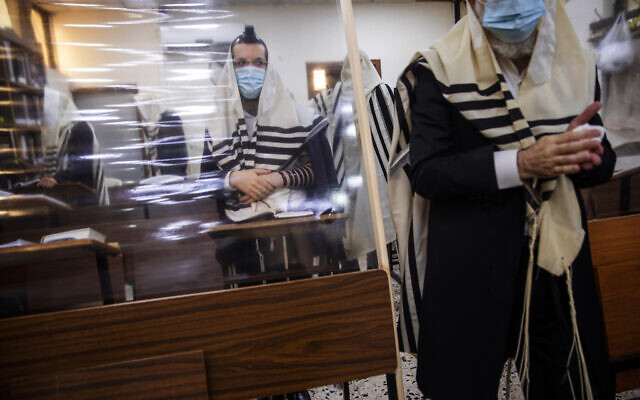 Ultra-Orthodox Jews, wearing face masks during morning prayers in a synagogue separated by plastic partitions, follow new government measures to help stop the spread of the coronavirus, in Bnei Brak, Sept 18, 2020. (AP Photo/Oded Balilty) Ultra-Orthodox Jews, wearing face masks during morning prayers in a synagogue separated by plastic partitions, follow new government measures to help stop the spread of the coronavirus, in Bnei Brak, Sept 18, 2020. (AP Photo/Oded Balilty)