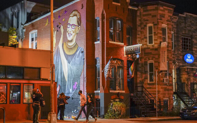 People gather under a mural of Supreme Court Justice Ruth Bader Ginsburg in the U Street neighborhood in Washington, Sept. 18, 2020, after the announcement that Ginsburg died of metastatic pancreatic cancer at age 87. (AP Photo/Pablo Martinez Monsivais)