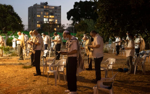 Israelis pray outside a synagogue ahead of Yom Kippur, the holiest day in the Jewish year in Tel Aviv, Israel,  Sept. 27, 2020. (AP Photo/Sebastian Scheiner)