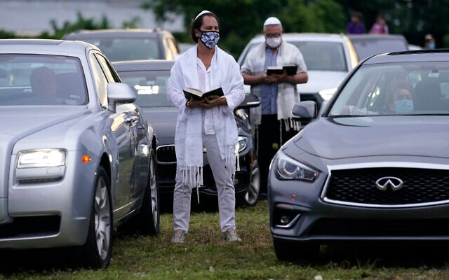 Illustrative: Congregants stand outside their vehicles during a Yom Kippur service hosted by the Aventura Turnberry Jewish Center, during the coronavirus pandemic, September 28, 2020, at the Dezerland Park drive-in theatre in North Miami, Florida. (AP Photo/Lynne Sladky)