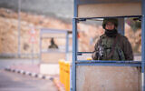 Israeli soldiers guard at a bus stop near the settlement of Kokhav HaShahar, in the West Bank, on January 6, 2019. (Yonatan Sindel/Flash90)