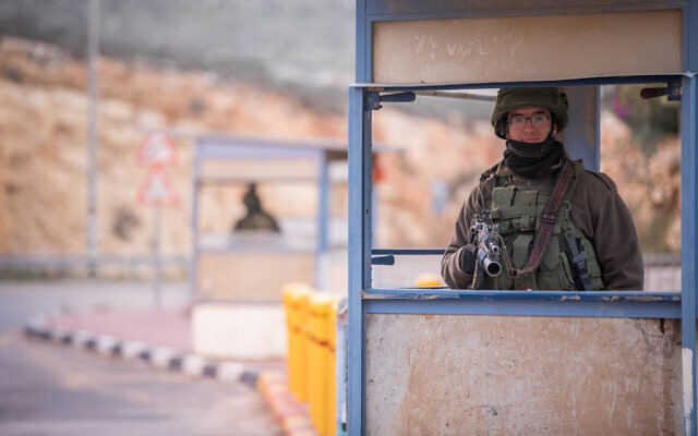 Israeli soldiers guard at a bus stop near the settlement of Kokhav HaShahar, in the West Bank, on January 6, 2019. (Yonatan Sindel/Flash90) Israeli soldiers guard at a bus stop near the settlement of Kokhav HaShahar, in the West Bank, on January 6, 2019. (Yonatan Sindel/Flash90)