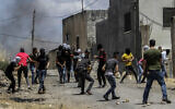 Palestinians clash with Israeli soldiers during a protest against Israel's plan to annex parts of the West Bank, in the village of Kfar Qaddum, near the West Bank city of Nablus on June 19, 2020. (Nasser Ishtayeh/Flash90)
