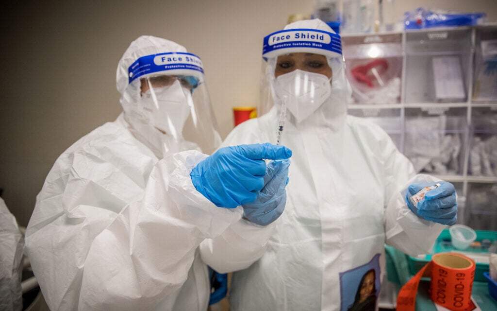 Staff wearing protective clothes work in the coronavirus ward at the Shamir Medical Center (Assaf Harofeh), near Tel Aviv, August 20, 2020. (Yonatan Sindel/Flash90) Staff wearing protective clothes work in the coronavirus ward at the Shamir Medical Center (Assaf Harofeh), near Tel Aviv, August 20, 2020. (Yonatan Sindel/Flash90)