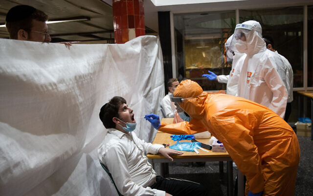 Illustrative: United Hatzalah workers wearing protective clothing as a preventive measure against the coronavirus test ultra-Orthodox Jewish men, at the Wolfson Yeshiva in Jerusalem on August 27, 2020. (Yonatan Sindel/Flash90) Illustrative: United Hatzalah workers wearing protective clothing as a preventive measure against the coronavirus test ultra-Orthodox Jewish men, at the Wolfson Yeshiva in Jerusalem on August 27, 2020. (Yonatan Sindel/Flash90)