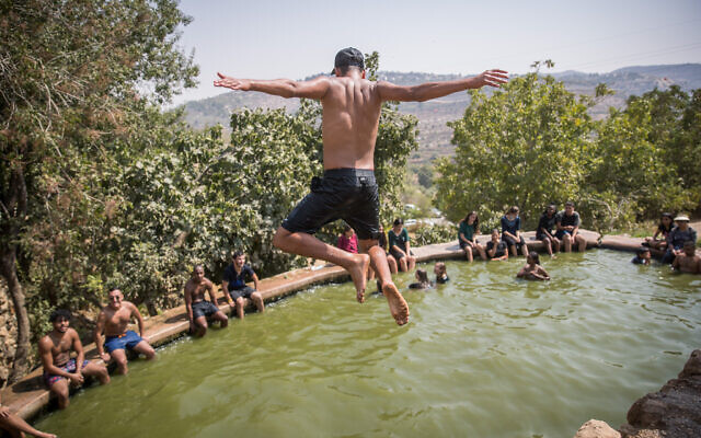 People enjoy a hot summer day at the Ein Lavan Spring in the Jerusalem Mountains, August 30, 2020. (Yonatan Sindel/Flash90)