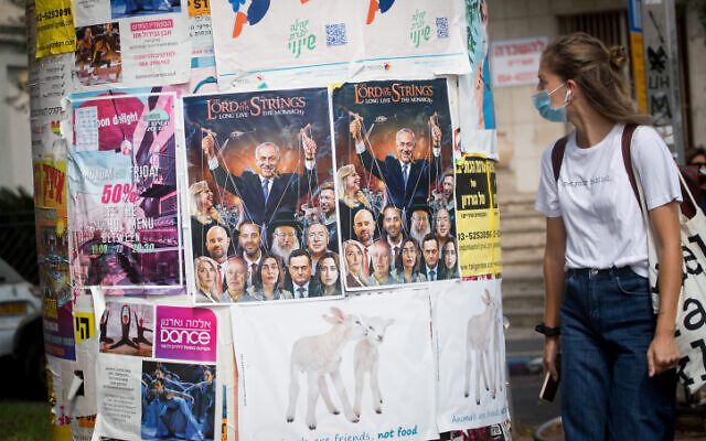 A woman walks by a poster critical of Prime Minister Benjamin Netanyahu's government, in Tel Aviv on September 10, 2020. (Miriam Alster/FLASH90) A woman walks by a poster critical of Prime Minister Benjamin Netanyahu's government, in Tel Aviv on September 10, 2020. (Miriam Alster/FLASH90)
