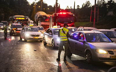 Israeli police at the entrance to the Jerusalem neighborhood of Ramot enforce a nightly curfew aimed at containing the coronavirus, September 13, 2020. (Yonatan Sindel/Flash90)
