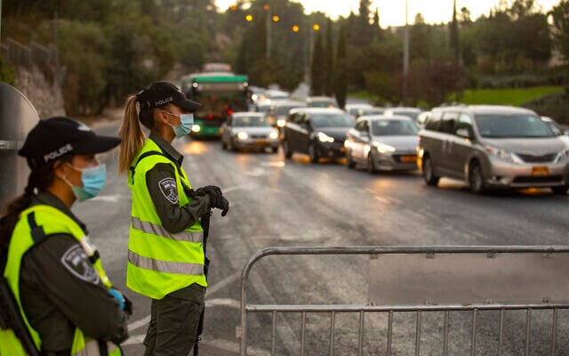 Israeli police seen at the entrance to the neighborhood of Ramot in Jerusalem as Israel enforces a night curfew, applied to some 40 cities all over Israel which have been badly affected by the coronavirus. September 13, 2020. (Yonatan Sindel/Flash90) Israeli police seen at the entrance to the neighborhood of Ramot in Jerusalem as Israel enforces a night curfew, applied to some 40 cities all over Israel which have been badly affected by the coronavirus. September 13, 2020. (Yonatan Sindel/Flash90)
