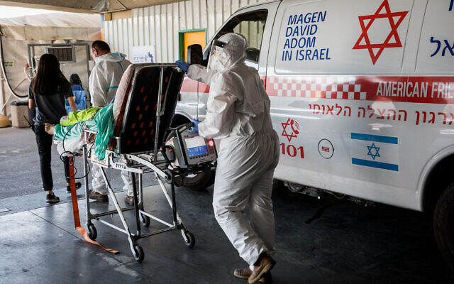 Magen David Adom workers wearing protective clothing outside the coronavirus unit at Shaare Zedek hospital in Jerusalem, September 14, 2020 (Nati Shohat/Flash90) Magen David Adom workers wearing protective clothing outside the coronavirus unit at Shaare Zedek hospital in Jerusalem, September 14, 2020 (Nati Shohat/Flash90)