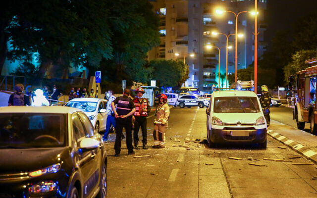 Police and medical personnel at the scene where a rocket fired from the Gaza Strip hit a road in the southern city of Ashdod on September 15, 2020 (Flash90) Police and medical personnel at the scene where a rocket fired from the Gaza Strip hit a road in the southern city of Ashdod on September 15, 2020 (Flash90)