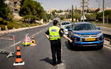 A police officer stops cars at a checkpoint in Jerusalem on September 20, 2020, amid a nationwide coronavirus lockdown. (Olivier Fitoussi/Flash90)
