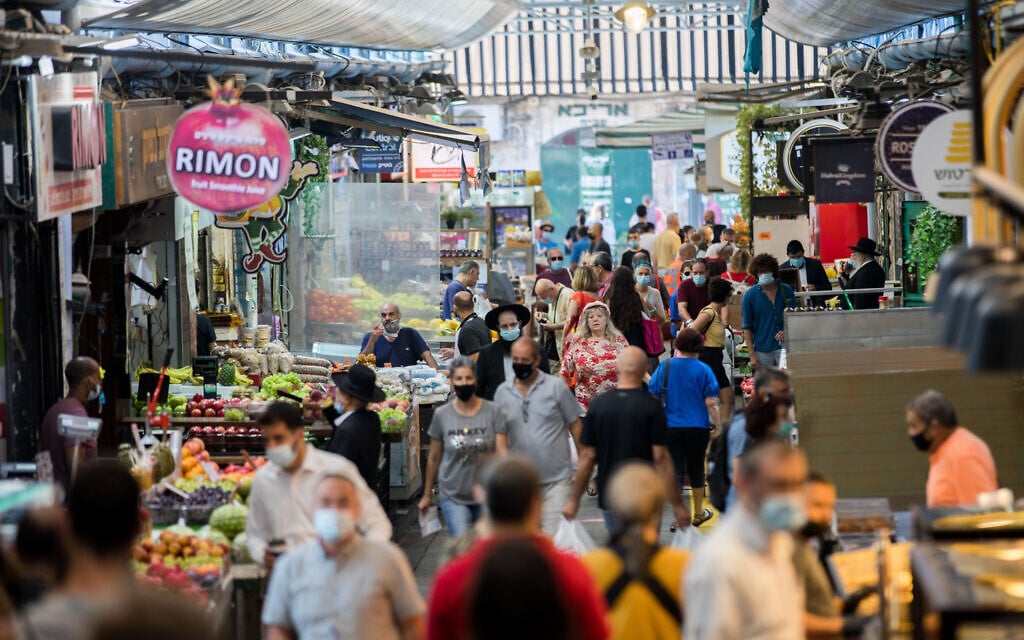 People, some of them wearing face masks, shop at the Mahane Yehuda Market in Jerusalem on September 25, 2020, during a nationwide lockdown to prevent the spread of COVID-19. (Yonatan Sindel/Flash90)
