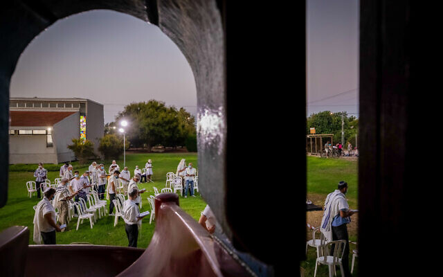 Jewish men pray at the end of Yom Kippur, the Day of Atonement, and the holiest of Jewish holidays, at a public space in Moshav Haniel, September 28, 2020 (Chen Leopold/Flash90)
