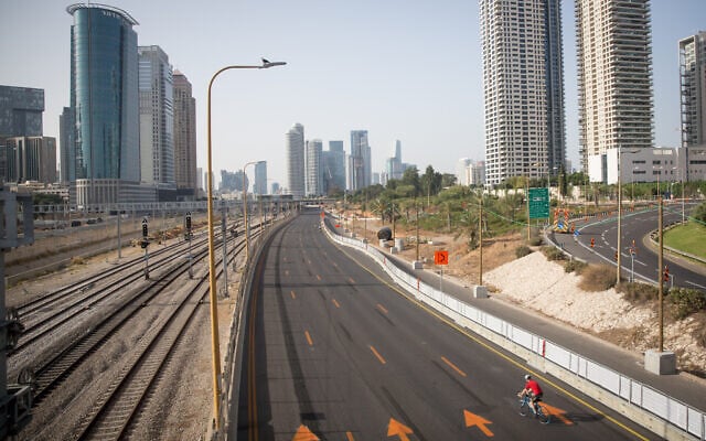 Israelis ride their bicycles along the empty Ayalon highway in Tel Aviv, on Yom Kippur, September 28, 2020 (Miriam Alster/Flash 90) Israelis ride their bicycles along the empty Ayalon highway in Tel Aviv, on Yom Kippur, September 28, 2020 (Miriam Alster/Flash 90)