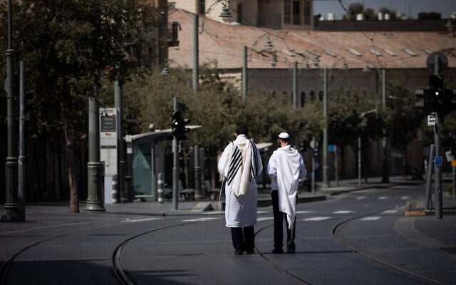 Jewish men walk with a prayer shawls in Jerusalem, on Yom Kippur, September 28, 2020 (Yonatan Sindel/Flash90)