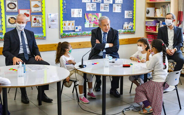 Prime Minister Benjamin Netanyahu (C) and Education Minister Yoav Gallant (L) visit Israeli kids on their first day of school in the Mevo Horon settlement on September 1, 2020. (Marc Israel Sellem/POOL) Prime Minister Benjamin Netanyahu (C) and Education Minister Yoav Gallant (L) visit Israeli kids on their first day of school in the Mevo Horon settlement on September 1, 2020. (Marc Israel Sellem/POOL)