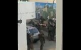 A screenshot from a video published September 5, 2020, showing Israeli troops carrying a pair of Palestinians on stretchers in the West Bank city of Jenin. (Screen capture: Twitter)