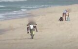 A man suspected of endangering beachgoers is seen driving on a motorcycle in the southern city of Ashdod on September 11, 2020. (Screen capture: YouTube)