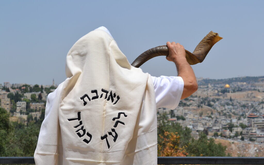 Jerusalemite Moshe Silver blows the shofar, or ram's horn, traditionally sounded on the Jewish new year of Rosh Hashanah, while wearing a prayer shawl emblazoned with the Hebrew phrase meaning, 'Love thy neighbor as thyself.' (Courtesy Reza Green) Jerusalemite Moshe Silver blows the shofar, or ram's horn, traditionally sounded on the Jewish new year of Rosh Hashanah, while wearing a prayer shawl emblazoned with the Hebrew phrase meaning, 'Love thy neighbor as thyself.' (Courtesy Reza Green)