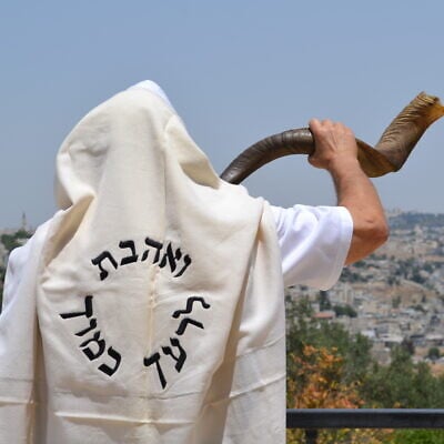 Jerusalemite Moshe Silver blows the shofar, or ram's horn, traditionally sounded on the Jewish new year of Rosh Hashanah, while wearing a prayer shawl emblazoned with the Hebrew phrase meaning, 'Love thy neighbor as thyself.' (Courtesy Reza Green)
