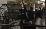 Screen capture from video of pilgrims tearing down metal barriers at the grave site complex of Rabbi Nachman of Breslov, in Uman, Ukraine, September 10, 2020. (YouTube)