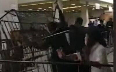 Screen capture from video of pilgrims tearing down metal barriers at the grave site complex of Rabbi Nachman of Breslov, in Uman, Ukraine, September 10, 2020. (YouTube)