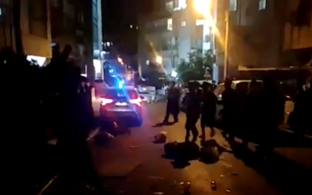 Bnei Brak residents surround a police vehicle enforcing a nightly curfew, September 13, 2020. (Screen capture: Twitter) Bnei Brak residents surround a police vehicle enforcing a nightly curfew, September 13, 2020. (Screen capture: Twitter)