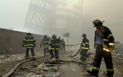 Firefighters work beneath the destroyed mullions, the vertical struts that once faced the outer walls of the World Trade Center towers, after the terrorist attack on the twin towers in New York, September 11, 2001. (AP Photo/Mark Lennihan, File)