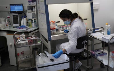 A lab technician prepares chemicals to process COVID-19 tests in Argenteuil, near Paris, Sept. 25, 2020. (AP Photo/Francois Mori)