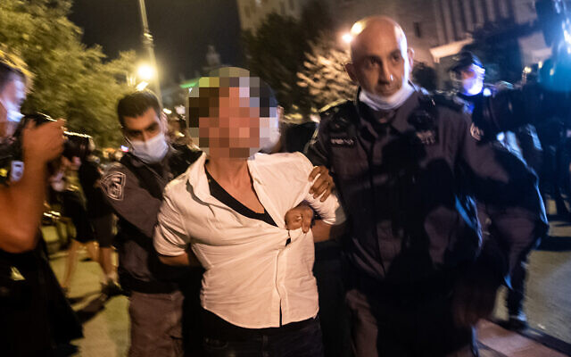 Police officers arrest a man who allegedly sped in his car toward protesters during a protest against Prime Minister Benjamin Netanyahu outside his official residence in Jerusalem, September 20, 2020. (Yonatan Sindel/Flash90)