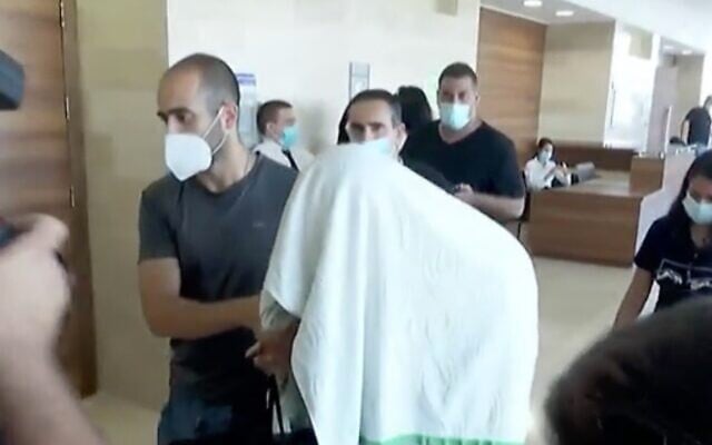 Screen capture from video of one of the suspects in a gang rape in Eilat arriving at the Beersheba District Court, September 3, 2020. (Channel 13 news) Screen capture from video of one of the suspects in a gang rape in Eilat arriving at the Beersheba District Court, September 3, 2020. (Channel 13 news)