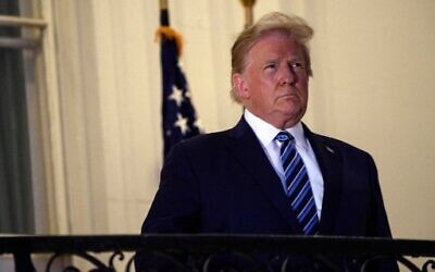 US President Donald Trump looks out from the Truman Balcony upon his return to the White House from Walter Reed Medical Center, where he underwent treatment for Covid-19, in Washington, DC, on October 5, 2020. (NICHOLAS KAMM/AFP)