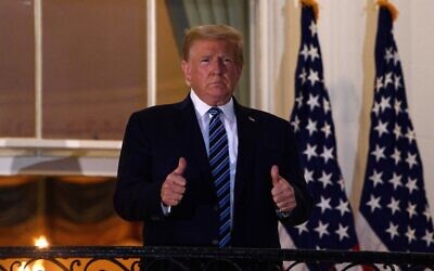 US President Donald Trump gives two thumbs up from the Truman Balcony upon his return to the White House in Washington from Walter Reed Medical Center, where he underwent treatment for COVID-19, October 5, 2020. (Nicholas Kamm/AFP)