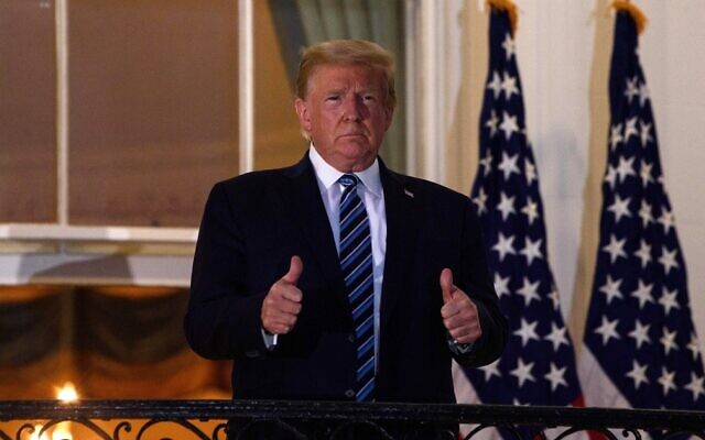 US President Donald Trump gives two thumbs up from the Truman Balcony upon his return to the White House in Washington from Walter Reed Medical Center, where he underwent treatment for COVID-19, October 5, 2020. (Nicholas Kamm/AFP) US President Donald Trump gives two thumbs up from the Truman Balcony upon his return to the White House in Washington from Walter Reed Medical Center, where he underwent treatment for COVID-19, October 5, 2020. (Nicholas Kamm/AFP)