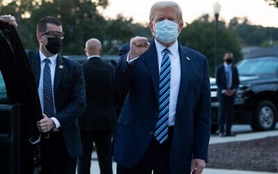 US President Donald Trump pumps his fist as he leaves Walter Reed Medical Center in Bethesda, Maryland, to return to the White House after being discharged, October 5, 2020. (Saul Loeb/AFP)
