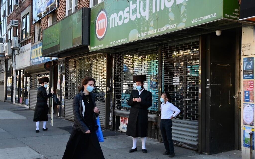 Illustrative: People walk past closed stores in the Borough Park section of Brooklyn, one of the five boroughs of New York City, on October 9, 2020. (Angela Weiss/AFP) Illustrative: People walk past closed stores in the Borough Park section of Brooklyn, one of the five boroughs of New York City, on October 9, 2020. (Angela Weiss/AFP)