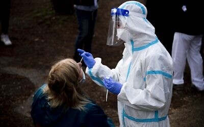 A woman undergoes a swab test for coronavirus at a drive-through testing site of the Santa Maria della Pieta hospital in Rome on October 12, 2020. (Tiziana Fabi/AFP)