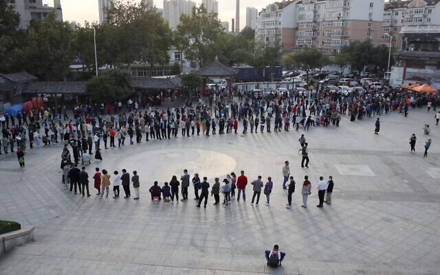 This photo taken on October 12, 2020 shows residents lining up to be tested for the COVID-19 coronavirus, as part of a mass testing program following a new coronavirus outbreak in Qingdao, in China's eastern Shandong province. (STR / AFP) / China OUT This photo taken on October 12, 2020 shows residents lining up to be tested for the COVID-19 coronavirus, as part of a mass testing program following a new coronavirus outbreak in Qingdao, in China's eastern Shandong province. (STR / AFP) / China OUT